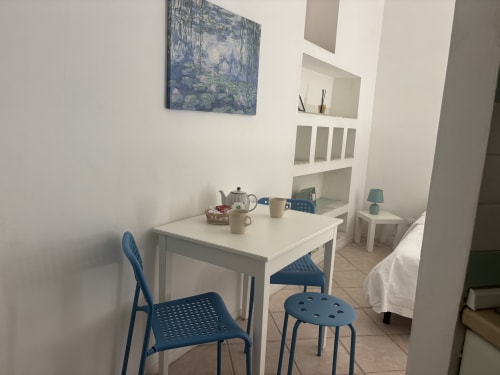 Studio San Gottardo a Lovelyloft Milano con tavolo da pranzo, sedie blu e angolo cottura