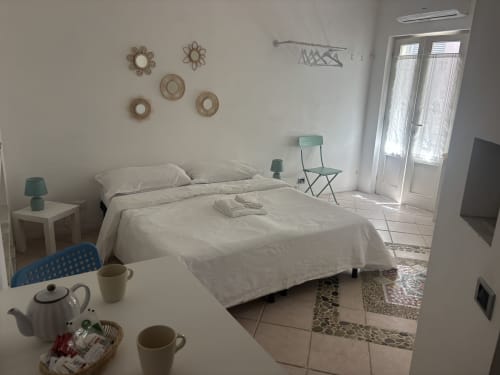 Luminoso monolocale a Lovelyloft Milano con letto, zona lavoro, angolo cottura e porte-finestre verso il balcone