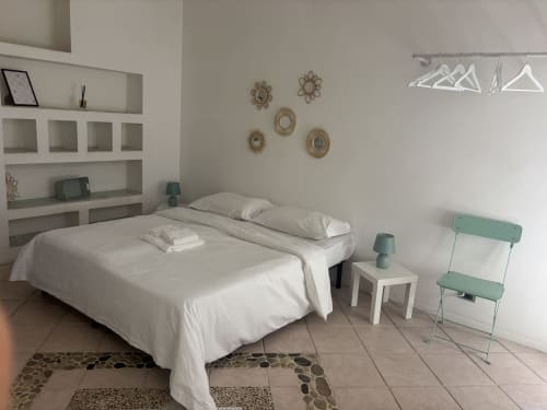 Camera moderna a Lovelyloft Milano con letto bianco, sedia turchese e arredamento minimalista