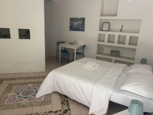 Moderno monolocale a Lovelyloft Milano con letto bianco, scrivania, scaffali e tocchi di blu