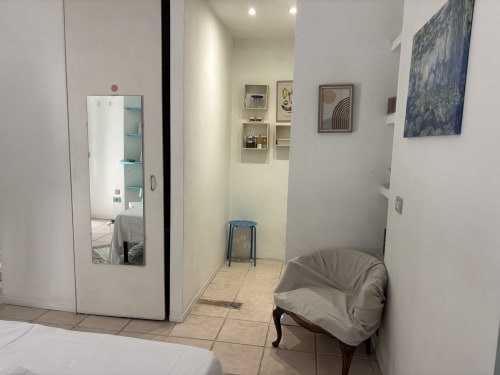 Lovelyloft Milano apartment entryway with mirror, shelving, blue stool, and chair