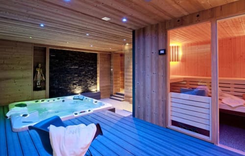 Espace spa luxueux aux Chalets d'Aline avec bain à remous, sauna et intérieurs en bois à La Plagne