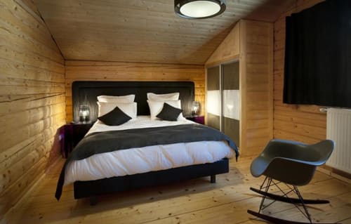 Chambre moderne en bois aux Chalets d'Aline, La Plagne avec lit queen-size, accents noirs et mobilier contemporain