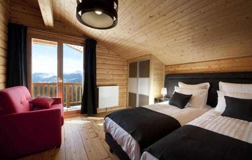 Chambre luxe du chalet Les Chalets d'Aline à La Plagne avec vue montagne, lits jumeaux et fauteuil rose