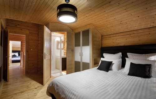 Chambre moderne en bois des Chalets d'Aline à La Plagne avec salle de bain attenante et ambiance de lodge montagnard