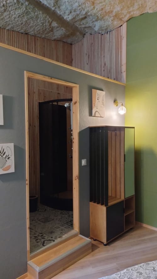 Entrée contemporaine de la Cave 1872 aux Troglos de Beaulieu avec porte en bois et mur d'accent vert