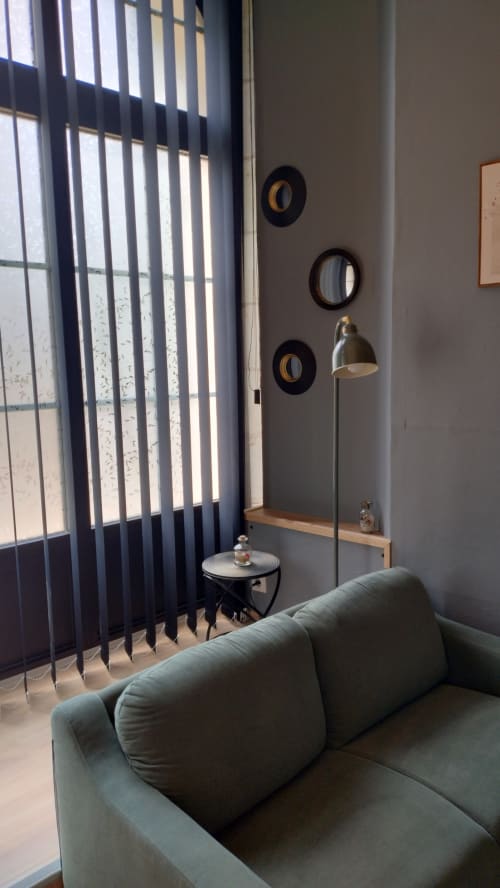 Coin salon moderne à La Cave 1872 des Troglos de Beaulieu avec canapé gris, rideaux rayés et vue sur le jardin