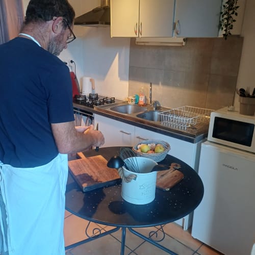 Homme cuisinant dans la cuisine moderne de la Préhistogite, gîte à Saint Gènies, France