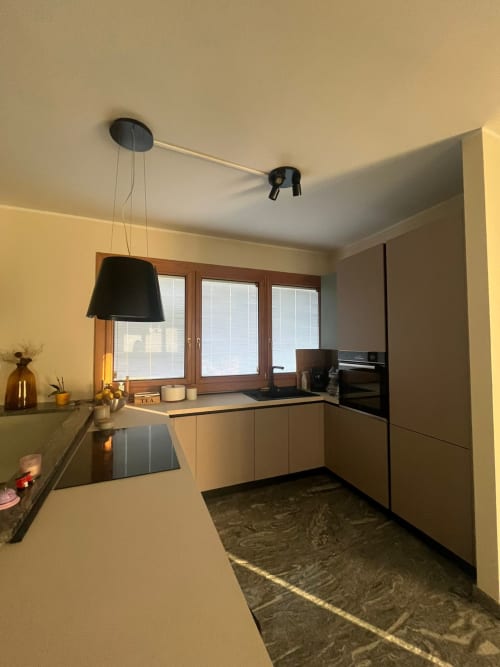 Cucina moderna nell'appartamento Casa Vacanze Luna 2 a Seriate, con mobili beige, piano cottura nero e cornici in legno