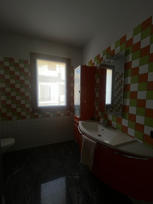 Bagno presso Casa Vacanze Foresteria Luna a Seriate con piastrelle a diamante colorate, lavabo curvo elegante e finestra con