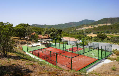 Tennis courts at Villa Nais in Bormes les Mimosas with mountain views and tree-lined setting