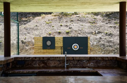 Indoor axe throwing range at Villa Nais B&B in Bormes les Mimosas with dartboard and target wall