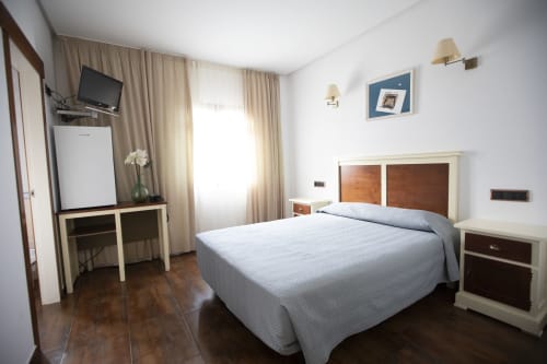 Espacioso dormitorio doble en Hostal Atalaya con cama queen, escritorio, TV y amenidades modernas en Minas de Riotinto