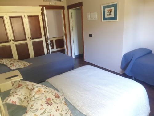 Habitación cuádruple del Hostal Atalaya en Minas de Ríotinto con múltiples camas, armarios y comodidades modernas