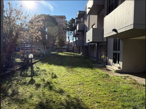 Cortile condiviso con prato verde presso Romagnapartments a Cervia, circondato da moderne residenze