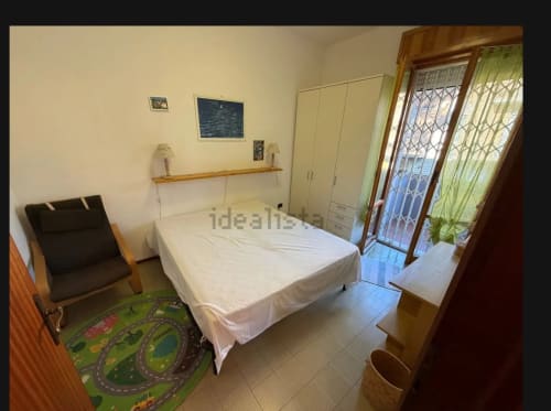 Camera luminosa presso Romagnapartments a Cervia con letto matrimoniale, mobili in legno e porta-finestra con vista sul giardino