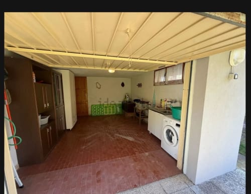 Cucina e zona living al piano terra con pavimento in cotto rosso, lavatrice e tenda da sole retrattile