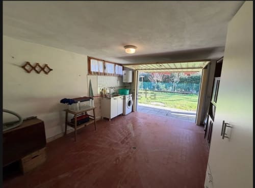 Ampia cucina e zona living nell'appartamento di Cervia con vista sul giardino, lavatrice/asciugatrice e accesso al patio