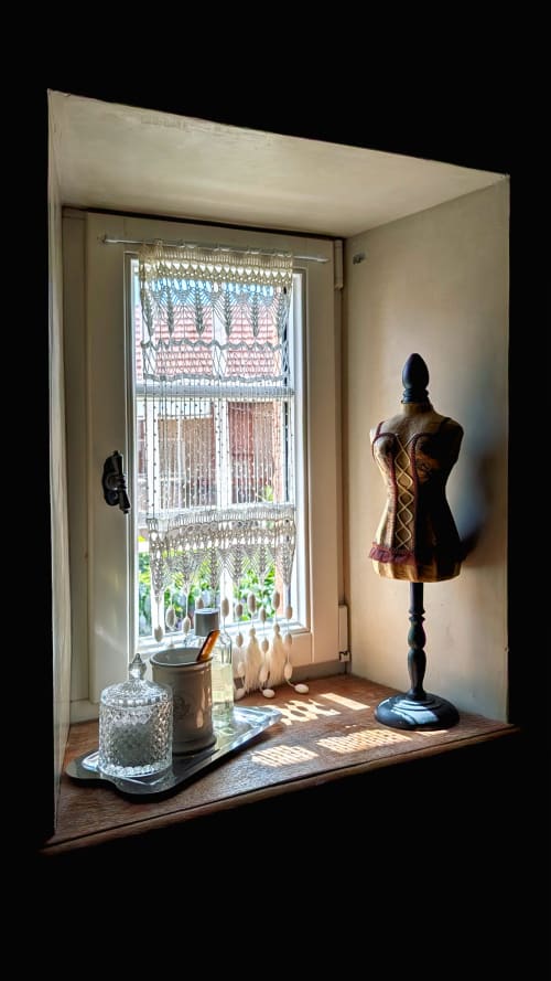 Vintage-styled room display at Domaine Au Fil Du Temps in Bouxwiller with dress form, decorative items, and lace curtains by