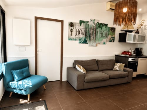 Salón moderno de Maison D'hôtes Coeur D'hérault con sillón turquesa, sofá marrón y decoración del hogar