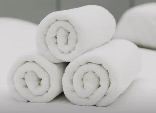 Serviettes de spa blanches roulées à La Villa des Pins, villa de luxe à Libreville