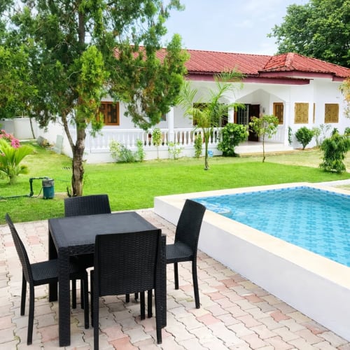 Villa des Pins à Libreville avec piscine, coin repas en terrasse et vue sur jardin luxuriant