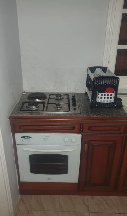 Kitchenette de la villa La Villa des Pins avec plaque de cuisson au gaz, four électrique et paniers de rangement