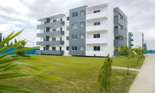 Immeuble moderne de La Villa des Pins à Libreville avec pelouse verte, jeunes arbres et architecture contemporaine