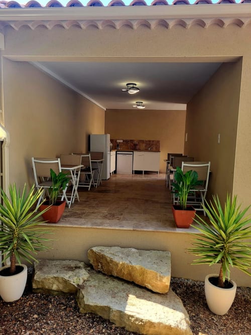 Salon commun L'Orée du Ventoux à Crillon-le-Brave avec sièges, coin cuisine et plantes tropicales