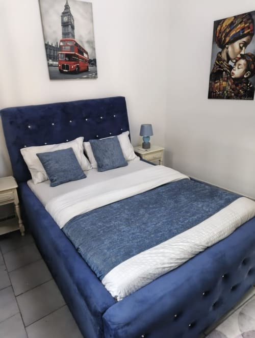 Lit rembourré bleu marine avec parure de lit bleue dans la chambre de La Villa des Pins, Akanda