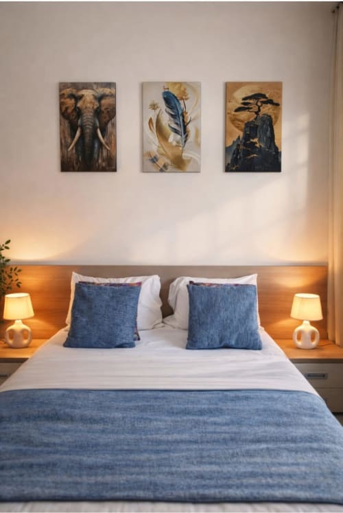 Chambre moderne à La Villa des Pins avec accents bleus, éclairage chaleureux et œuvres animalières au-dessus du lit
