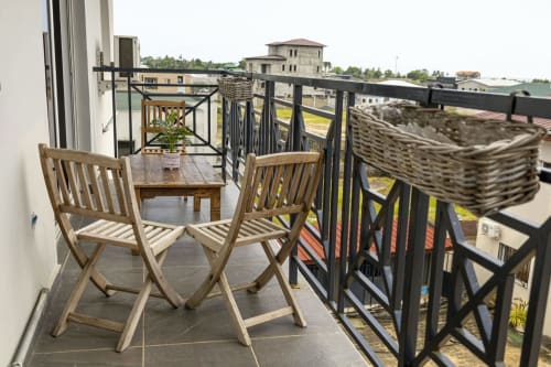 Chaises longues en bois sur balcon surplombant la marina et les bâtiments de La Villa des Pins, Akanda