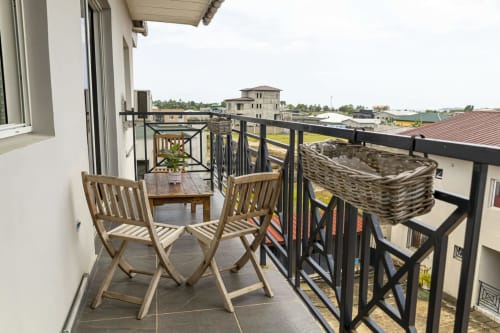 Balcon privé avec chaises en bois et vue sur la côte à La Villa des Pins, Akanda, Gabon