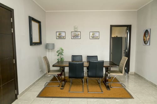 Salle à manger contemporaine de l'appartement La Villa des Pins à Akanda avec table, chaises noires et accès à la vue sur mer