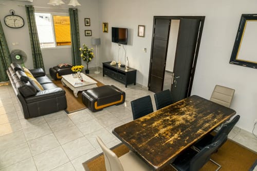 Séjour moderne à La Villa des Pins, Akanda avec sièges en cuir noir, table à manger et accès à la vue mer
