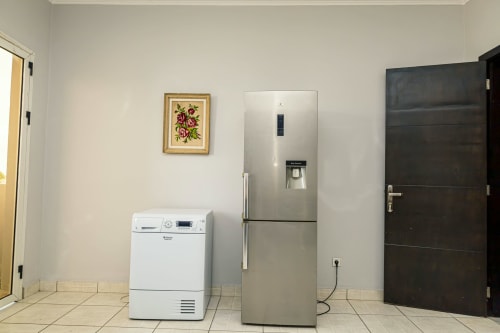 Cuisine moderne de La Villa des Pins Marina 1 à Akanda avec réfrigérateur en acier inoxydable et électroménagers blancs