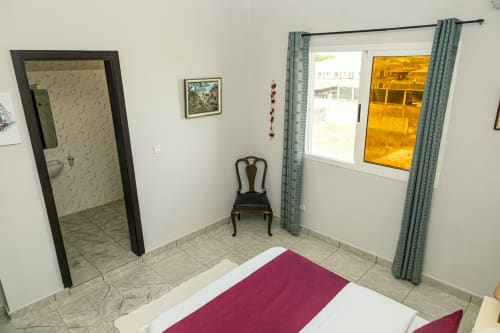Chambre de l'appartement Marina à La Villa des Pins, Akanda avec vue sur mer, lit, fauteuil et fenêtre
