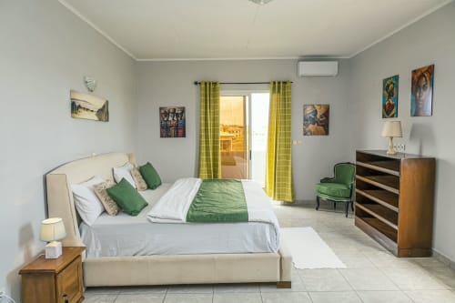Chambre spacieuse de l'appartement Marina à La Villa des Pins, Akanda avec vue sur mer, literie verte et équipements modernes