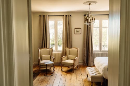 Chambre élégante au Château Alto Cormeil à Saint-Émilion avec fauteuils d'époque, parquets et lustre