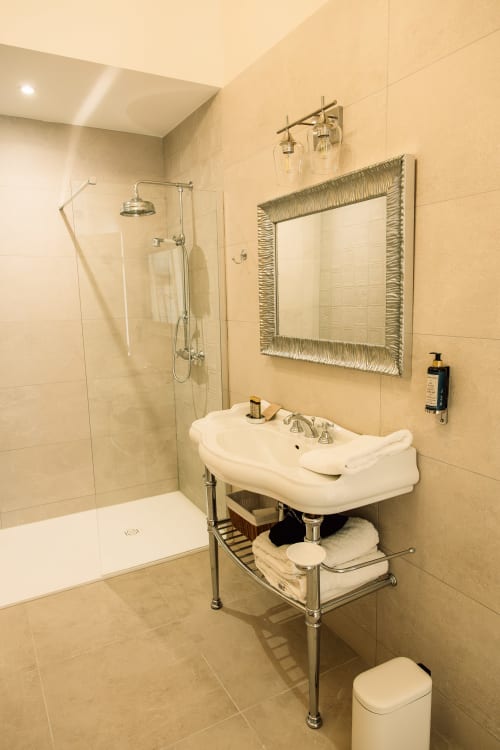 Salle de bain moderne avec lavabo sur colonne, douche à l'italienne et miroir décoratif au Château Alto Cormeil, Saint-Émilion