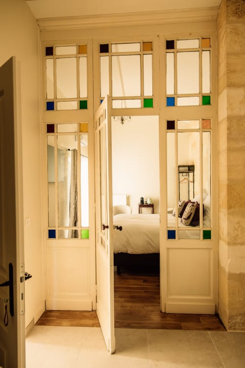 Portes vitrées élégantes couleur crème s'ouvrant sur la chambre de la Chambre Le Cuvier au Château Alto Cormeil, Gîte Saint-Émilion