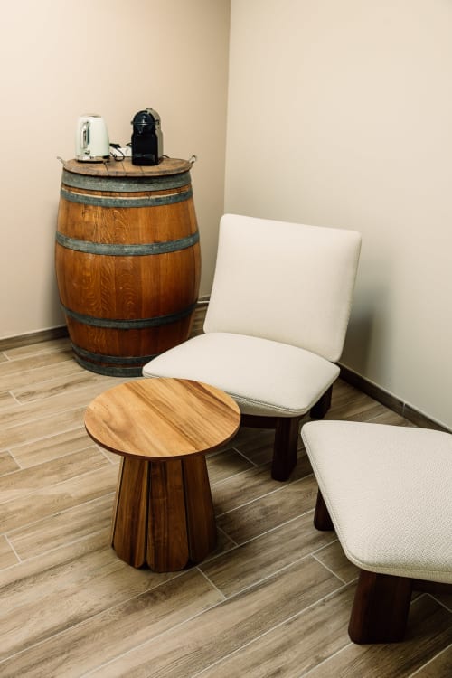 Salon cosy de la Chambre Le Chai au Château Alto Cormeil avec fauteuils crème, table d'appoint en bois et tonneau décoratif