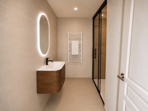 Salle de bain moderne au Château Alto Cormeil, Saint-Émilion avec miroir ovale illuminé, meuble-lavabo en bois et porte-serviettes blanc