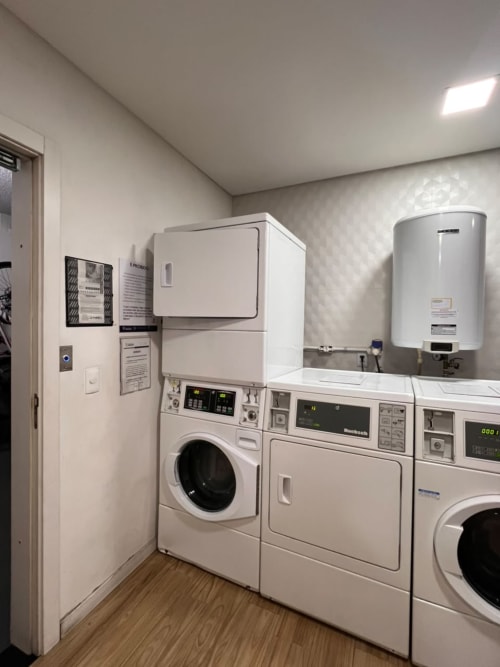 Moderna lavanderia no apartamento BORA BORA HOSPEDAGENS em Joinville com máquinas de lavar, secadoras, aquecedor de água e piso em madeira