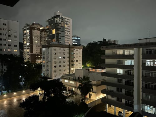 Vista noturna da região central de Joinville com edifícios residenciais iluminados próximo ao Mueller Shopping