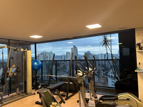 Moderno ginásio com vista da cidade de Joinville no apartamento BORA BORA HOSPEDAGENS, equipamentos de exercício e skyline