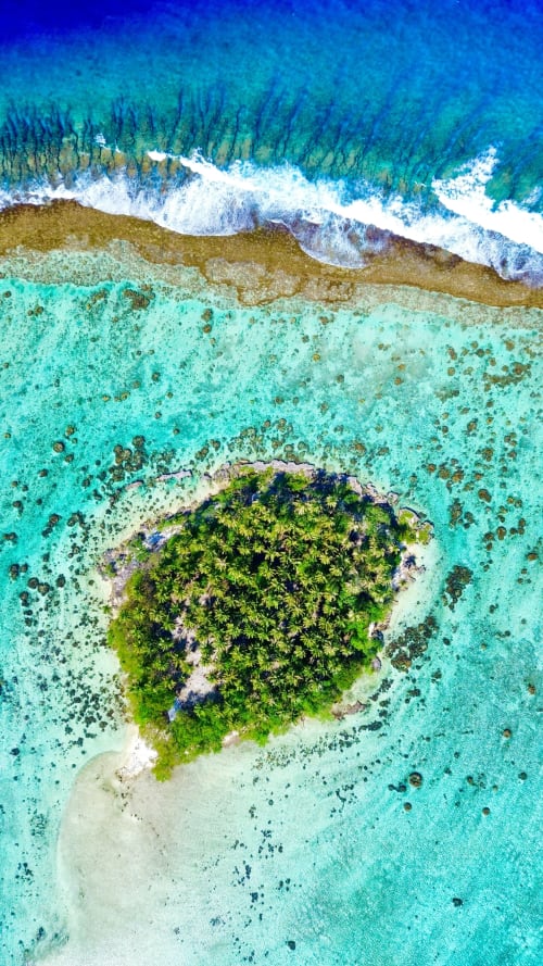 Vue aérienne de l'île tropicale luxuriante entourée d'un lagon turquoise et d'une plage de sable blanc près de l'OPOA BEACH HÔTEL, Uturoa