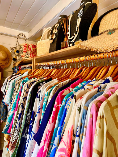Colorful clothing rack display at OPOA Beach Hôtel in Uturoa with wooden hangers and decorative beach accessories