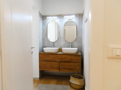 Modern bathroom in San Marco Luxury Suites Verona with dual white vessel sinks, wooden vanity, mirrors, and gray tile