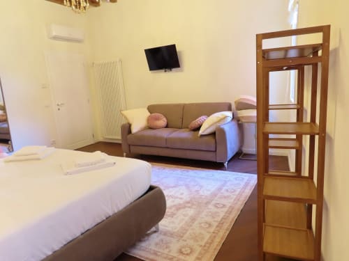 Spacious Suite Superior at San Marco Luxury Suites in Verona with queen bed, sofa, flat-screen TV, and wooden furnishings